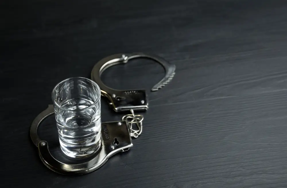 Alcohol addiction, handcuffed with an alcohol glass