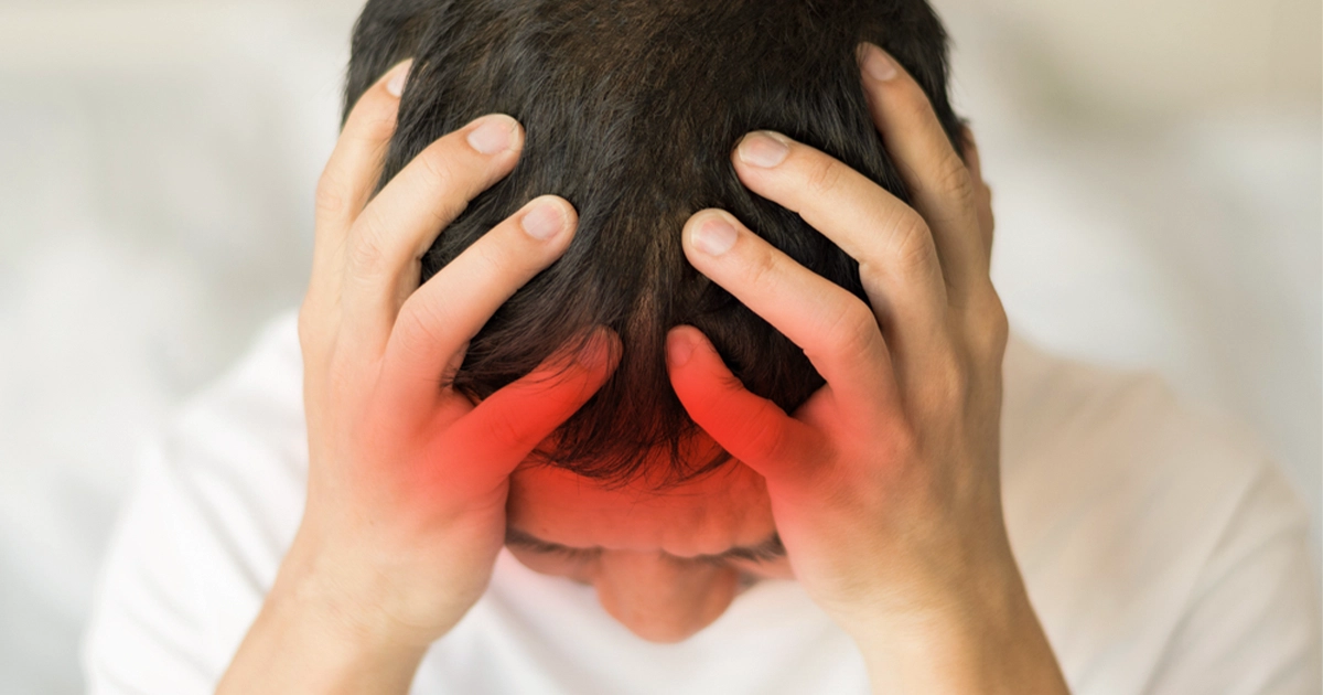Person clutching head showing pain from concussion symptoms