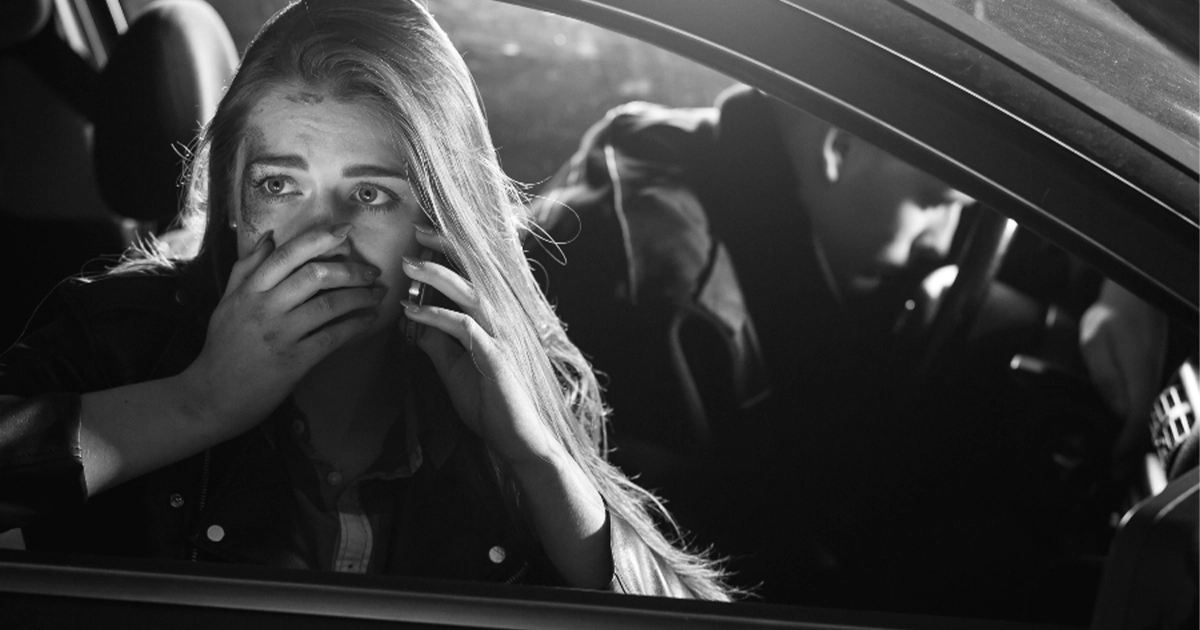 Shocked woman in vehicle experiencing anxiety after crash