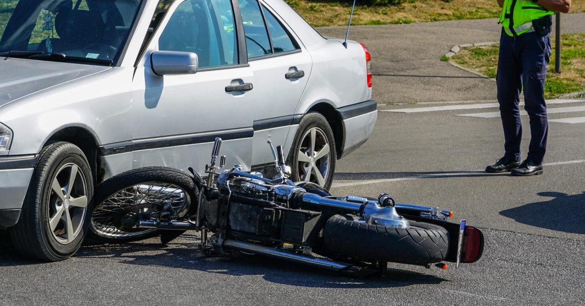 A scene of a motorcycle accident on a road with a police officer, representing the legal process of a motorcycle lawsuit.